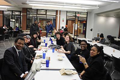 A long table shot of students who participate in Center for 多样性 and 包容 programming gathering for dinner in the 餐厅 Hall. 