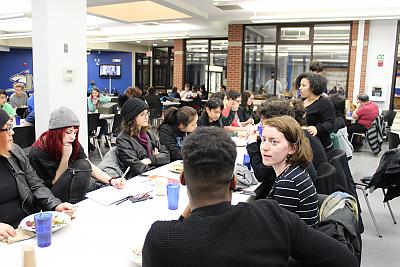 Another long table shot of students who participate in Center for 多样性 and 包容 programming gathering for dinner in the 餐厅 Hall. This time,y are eng年龄d in conversation rather than posing for a picture. 